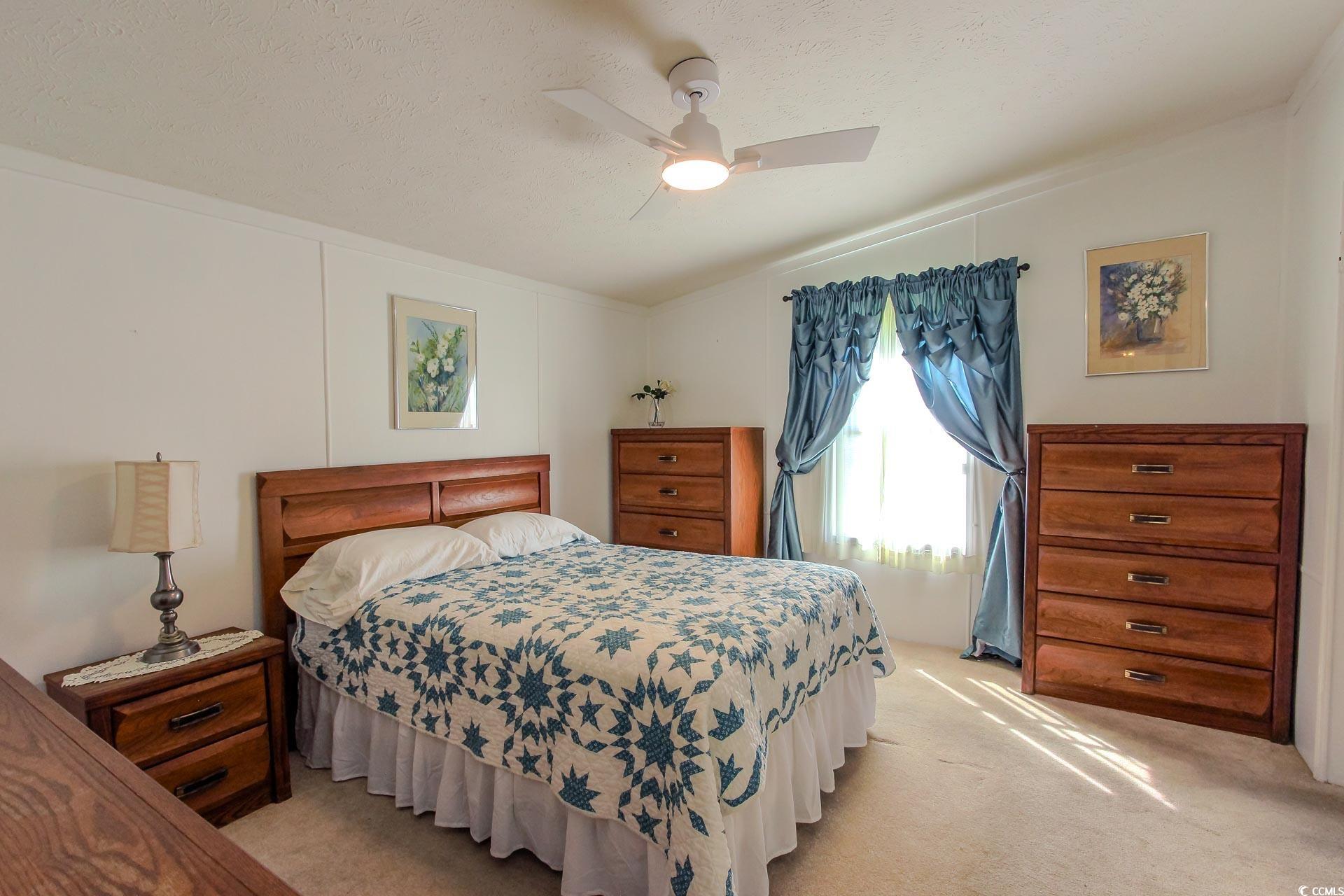 163 Crooked Island Circle Murrells Inlet, SC 29576 - Photo 15 of 40 Carpeted bedroom with ceiling fan, a textured ceiling, and lofted ceiling
