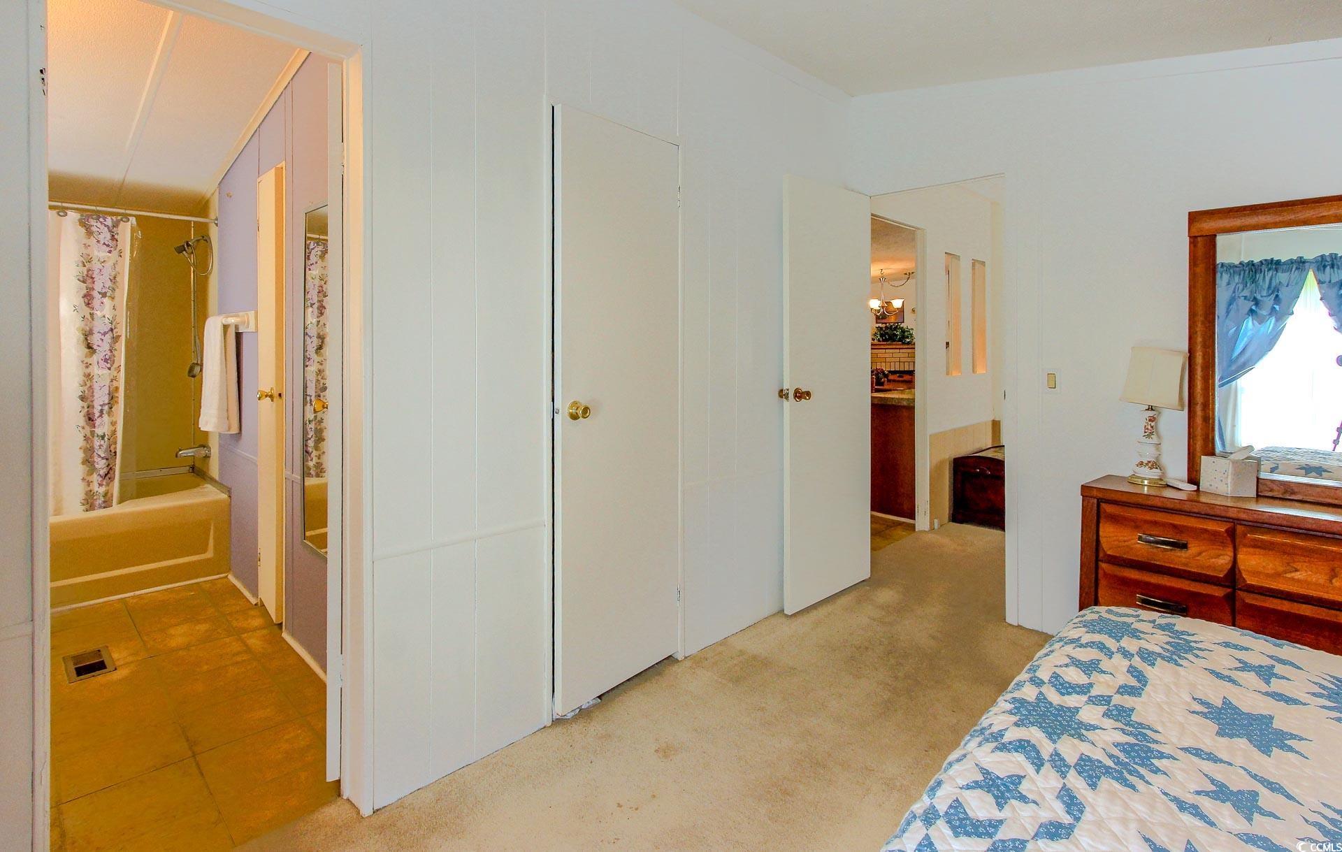 163 Crooked Island Circle Murrells Inlet, SC 29576 - Photo 17 of 40 Bedroom featuring light colored carpet, a closet, and ensuite bath