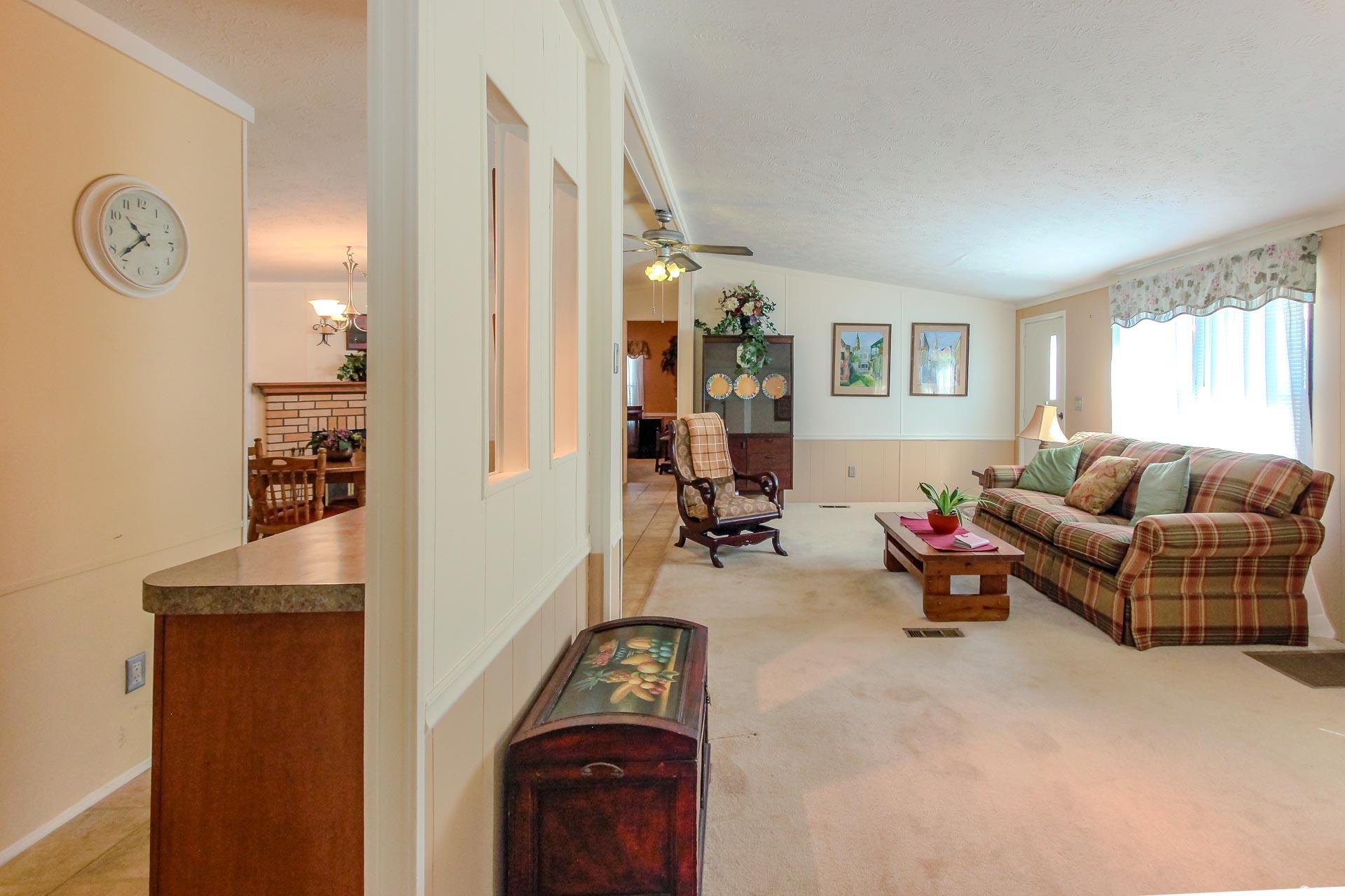 163 Crooked Island Circle Murrells Inlet, SC 29576 - Photo 7 of 40 Living area with vaulted ceiling, ceiling fan, light colored carpet, a textured ceiling, and a chandelier