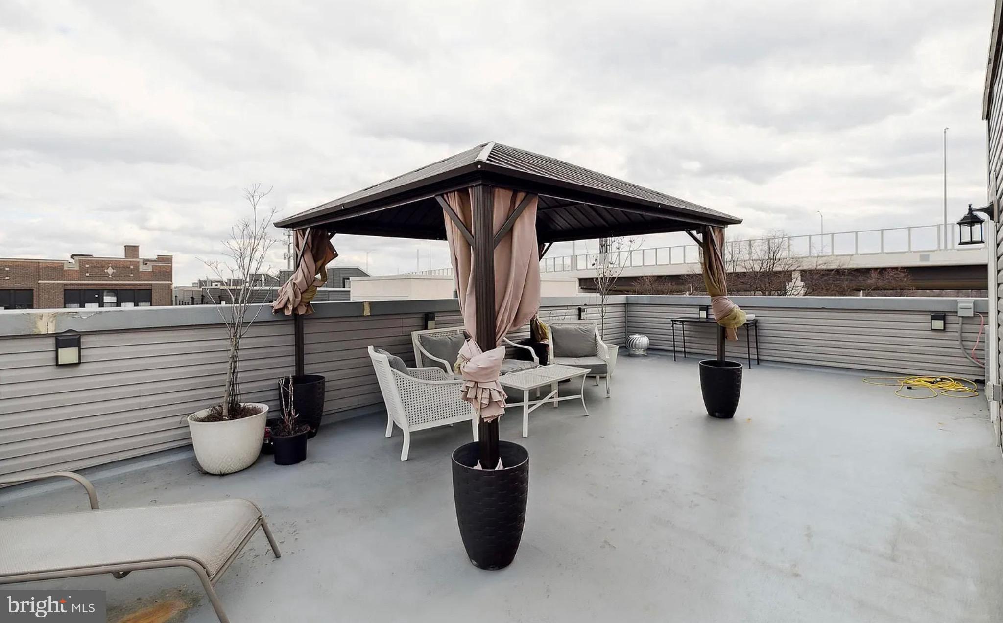 2813 Tilton Street Philadelphia, PA 19134 - Photo 27 of 33 a roof deck with a table and chairs and potted plants