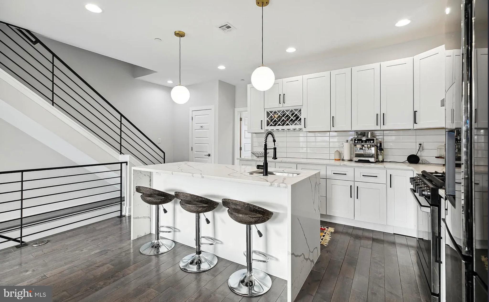2813 Tilton Street Philadelphia, PA 19134 - Photo 8 of 33 a kitchen with kitchen island a dining table chairs sink and white appliances