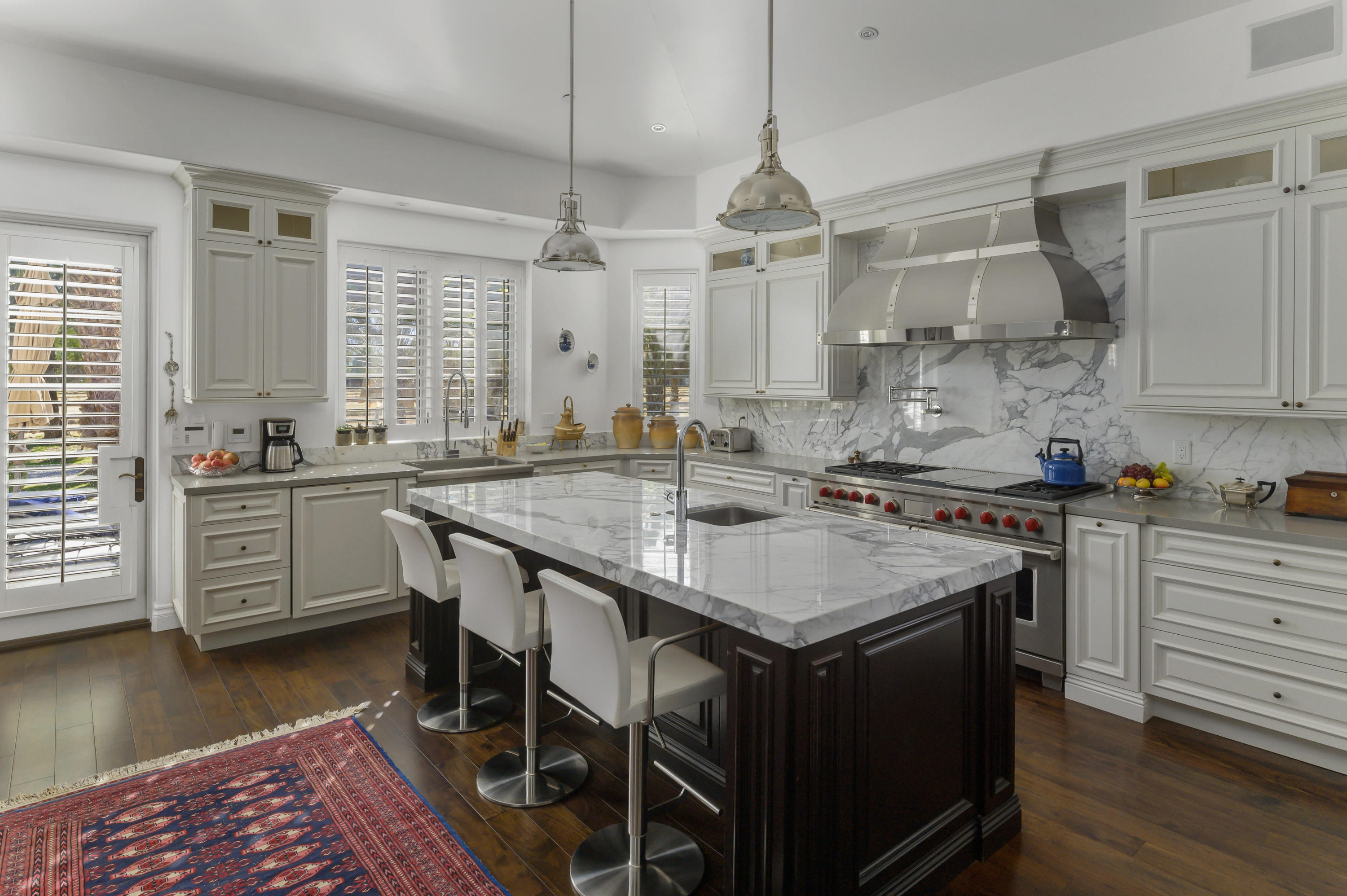 82425 Ave 55 Thermal, CA 92274 - Photo 12 of 46 a kitchen with stainless steel appliances granite countertop a stove a sink dishwasher a dining table and chairs with wooden floor