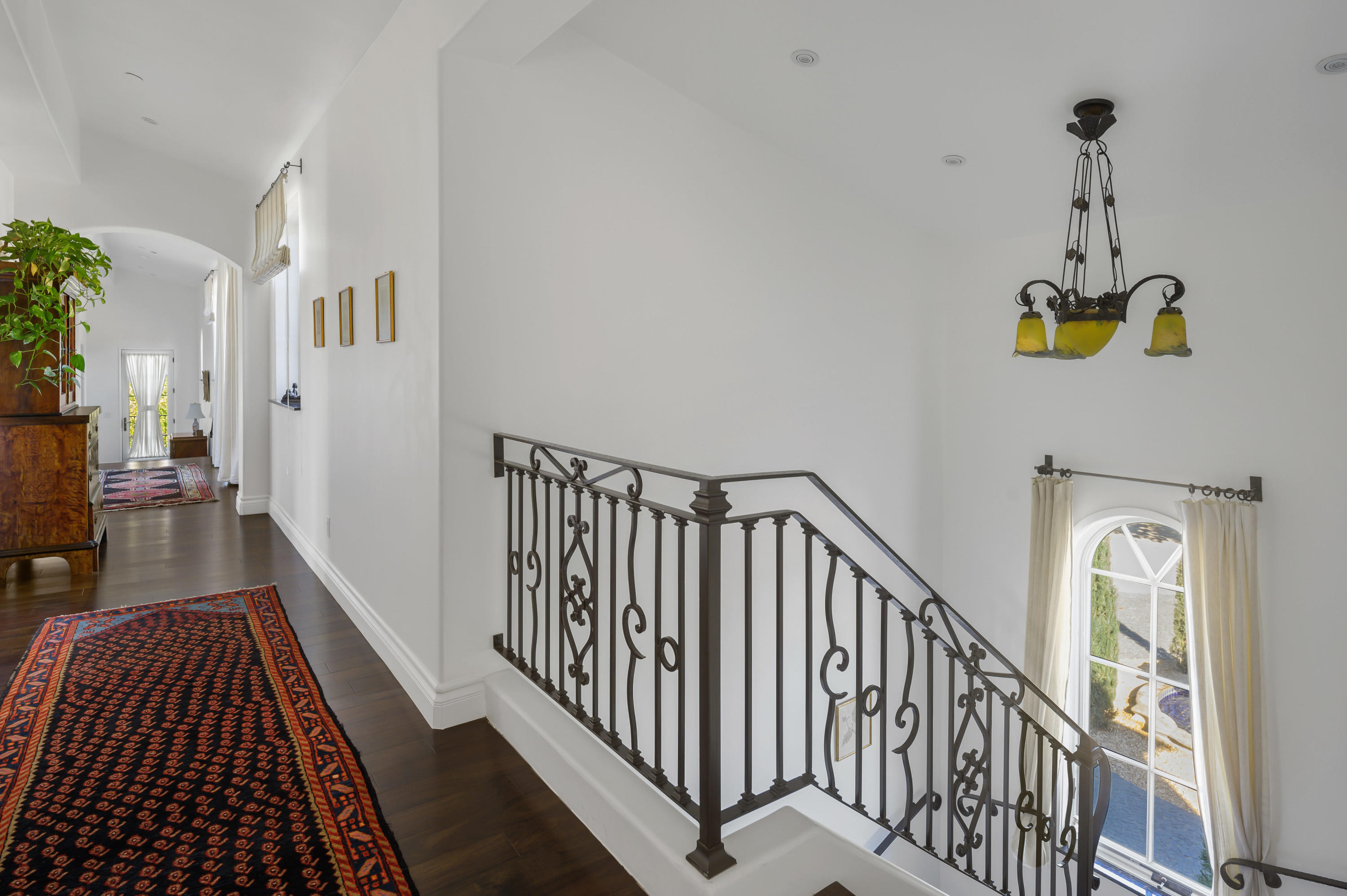 82425 Ave 55 Thermal, CA 92274 - Photo 33 of 46 a view of staircase with lots of frames on wall and a wooden floor