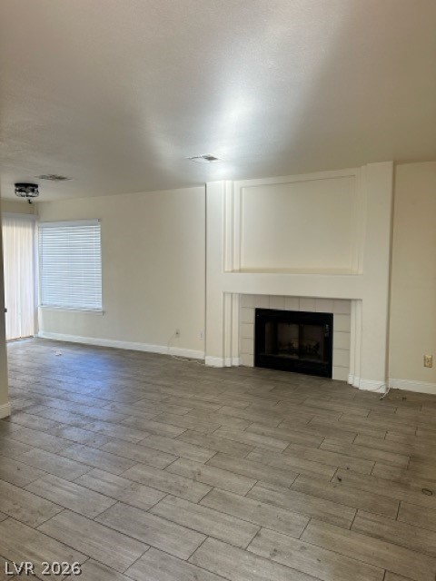 2152 Falcon Pointe Lane Henderson, NV 89074 - Photo 6 of 11 Unfurnished living room featuring a tile fireplace and light wood-style floors