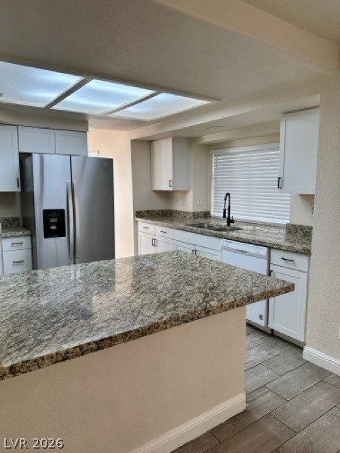 2152 Falcon Pointe Lane Henderson, NV 89074 - Photo 9 of 11 Kitchen with dark stone countertops, white cabinetry, and light wood-style flooring