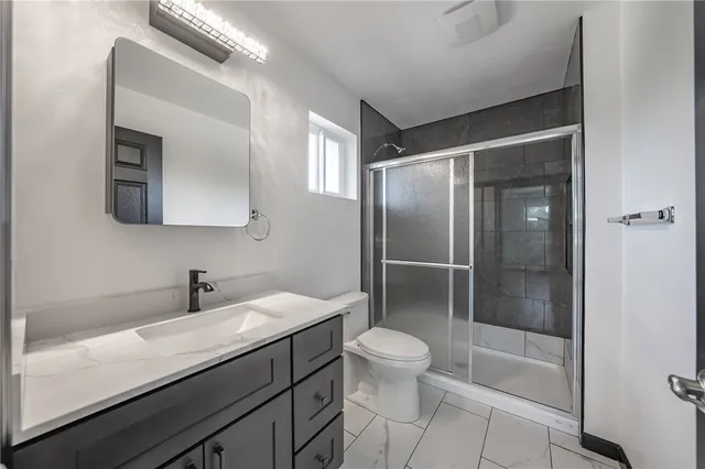 a bathroom with a sink a toilet and shower