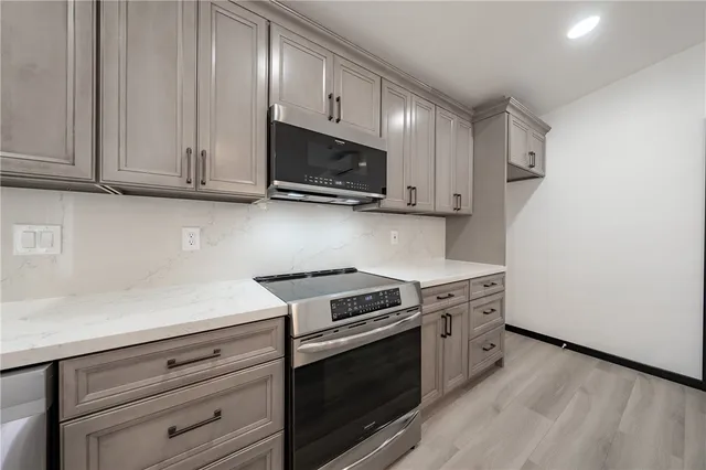 a kitchen with granite countertop cabinets stainless steel appliances and wooden floor