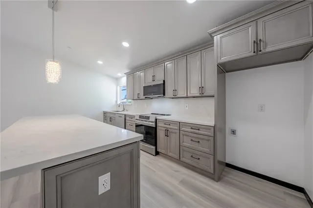 a kitchen with stainless steel appliances white cabinets and wooden floors