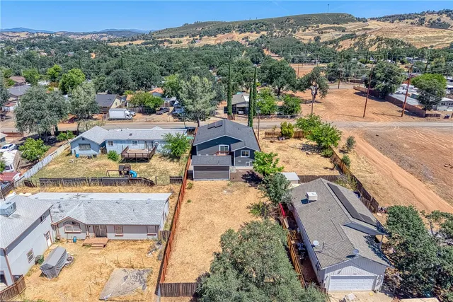 an aerial view of residential houses with outdoor space and trees