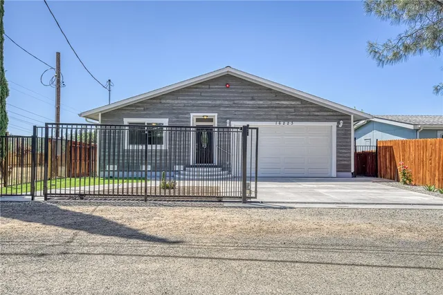 a view of a house with a small yard and wooden fence