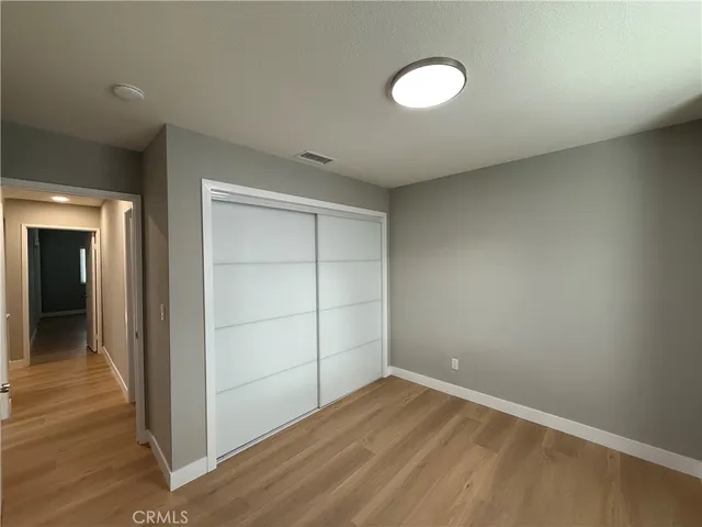 a view of a hallway to a room with wooden floor and stairs