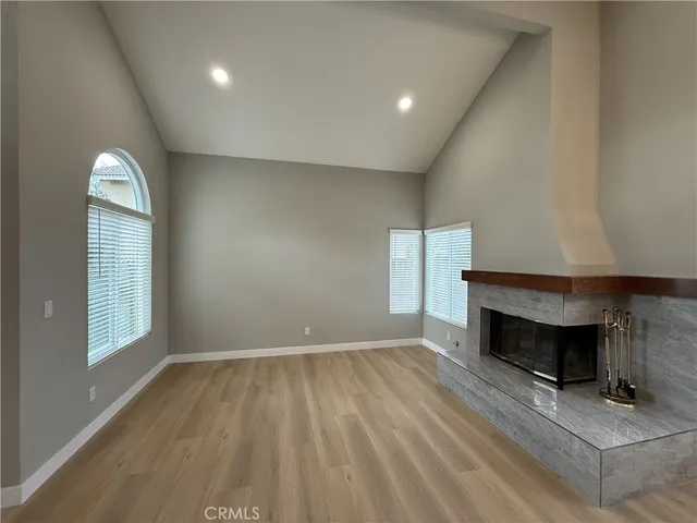 an empty room with windows and fireplace