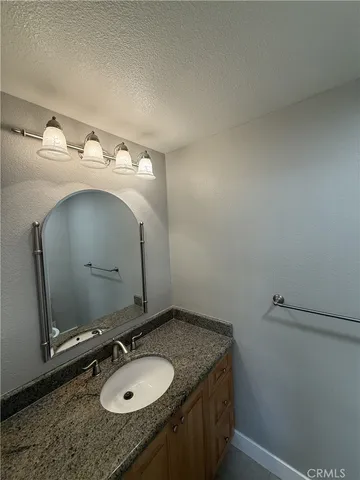 a bathroom with a granite countertop sink and a mirror