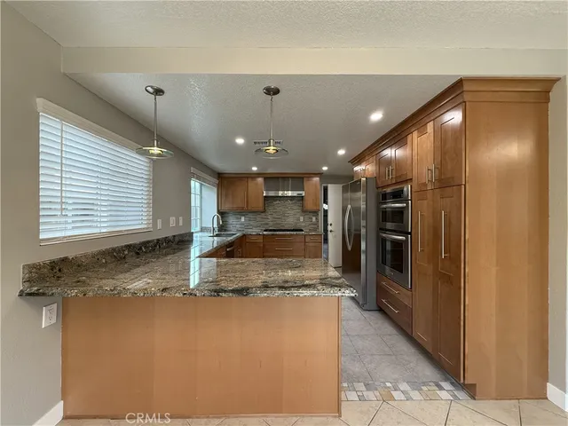 a kitchen with kitchen island a counter top space stainless steel appliances and a window