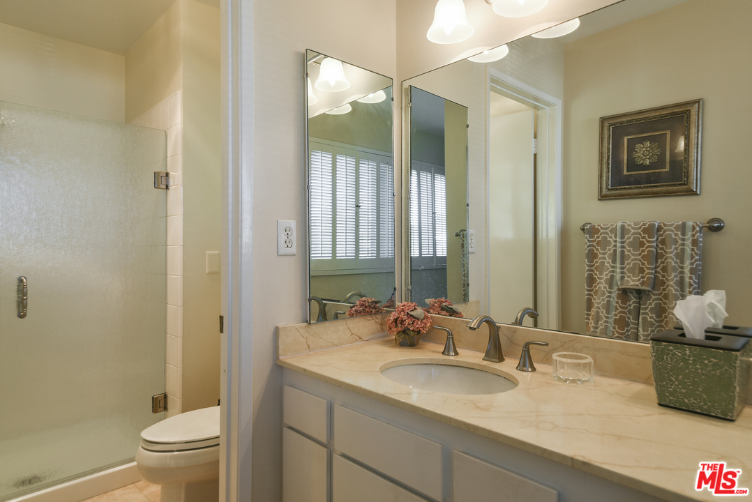 4875 Patrae Street Los Angeles, CA 90066 - Photo 17 of 23 a bathroom with a granite countertop sink a toilet and a mirror