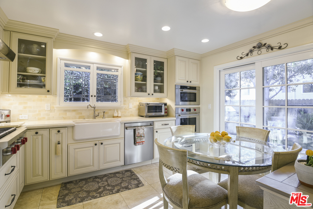 4875 Patrae Street Los Angeles, CA 90066 - Photo 8 of 23 a kitchen with a stove a sink dishwasher a dining table and chairs with wooden floor