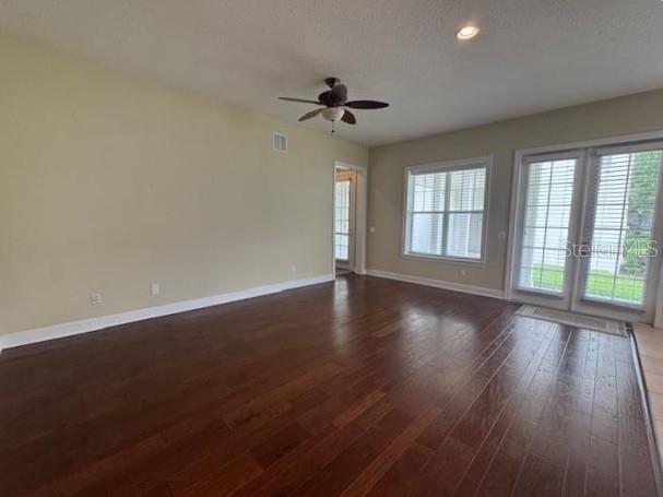 1442 Stickley Avenue Celebration, FL 34747 - Photo 10 of 46 an empty room with wooden floor chandelier fan and windows