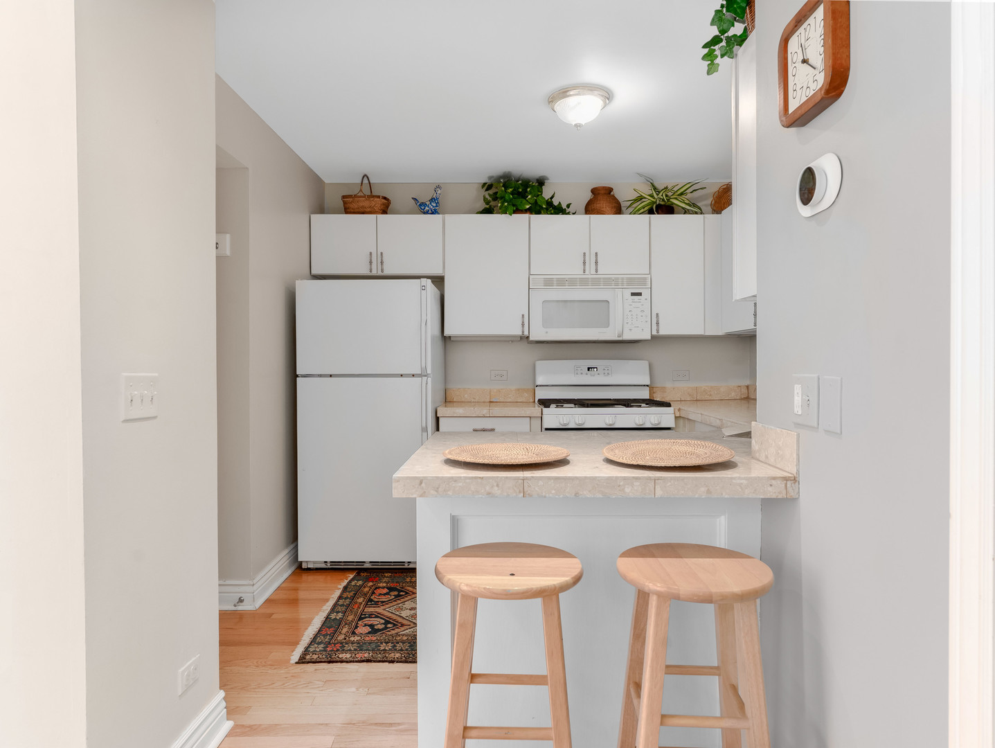 471 River Bend Road, Unit 107 Naperville, IL 60540 - Photo 12 of 31 a kitchen with stainless steel appliances granite countertop a stove a refrigerator and a dining table with wooden floor