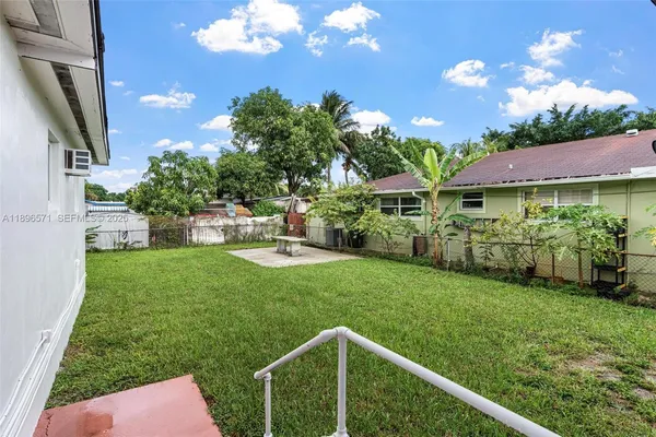 a view of a house with a yard and potted plants