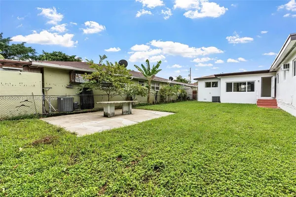 a view of a house with a backyard and a patio