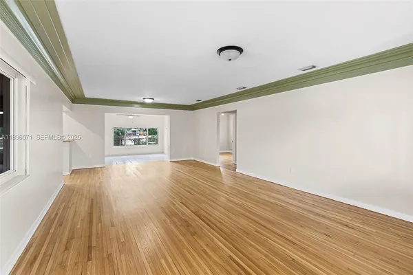a view of a room with wooden floor and a window