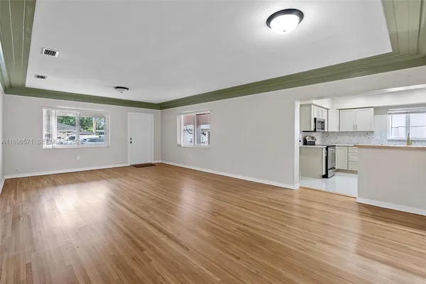 a view of empty room with wooden floor