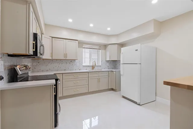 a kitchen with a refrigerator sink stove and cabinets