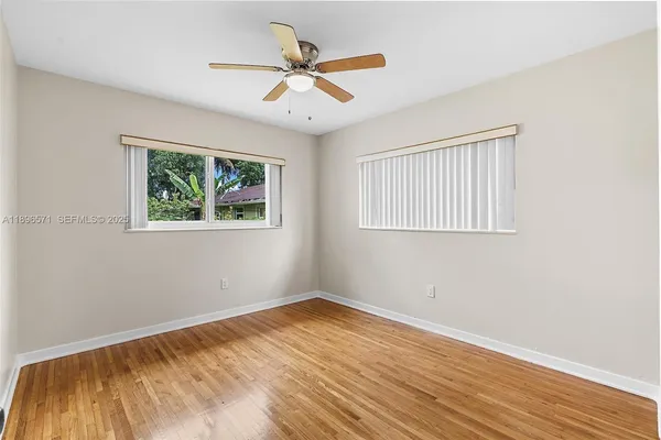 a view of empty room with wooden floor