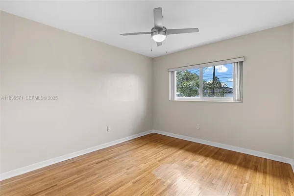 a view of empty room with wooden floor