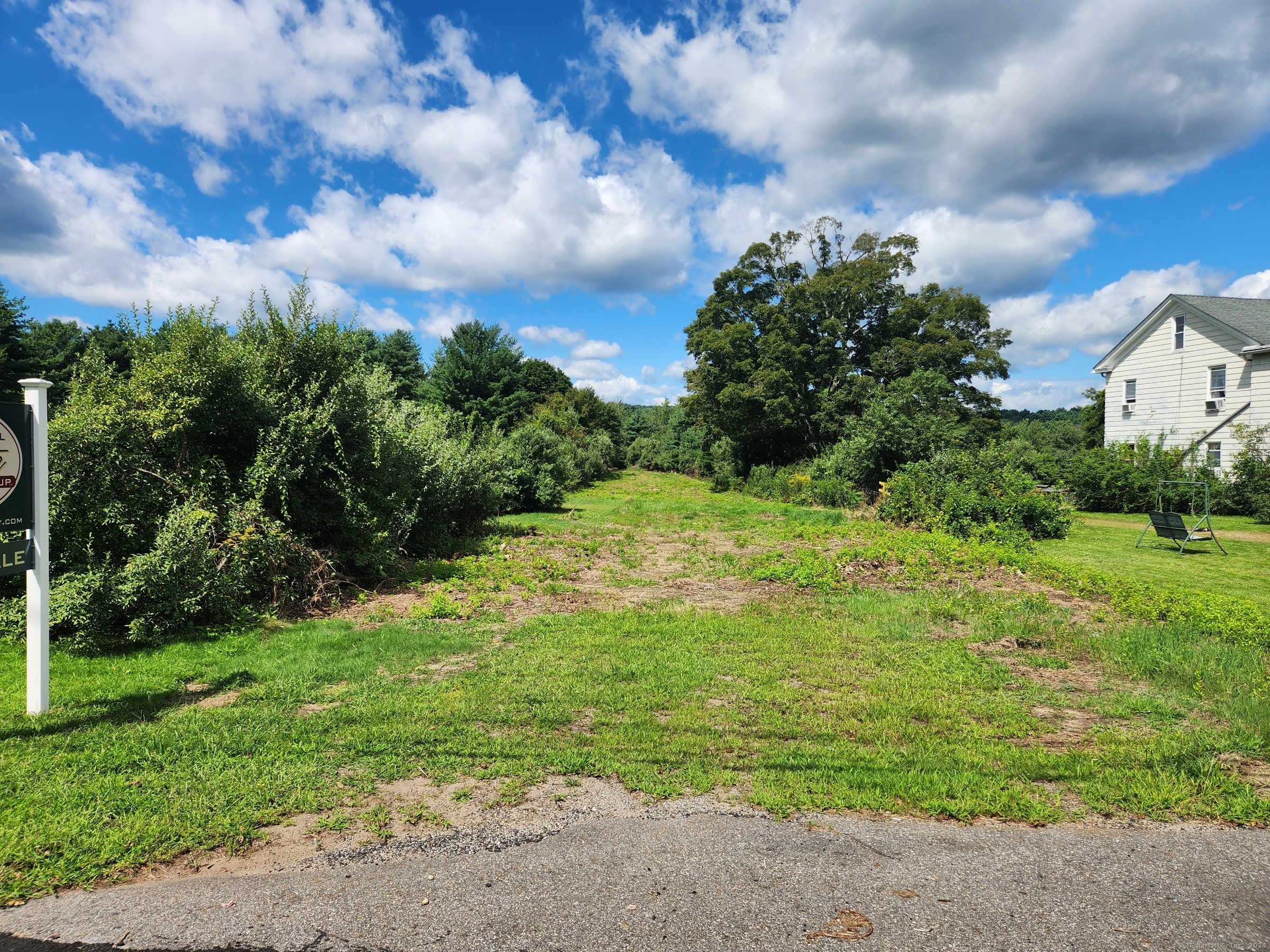 83 River Road Willington, CT 06279 - Photo 1 of 11 a backyard of a house with plants and large trees