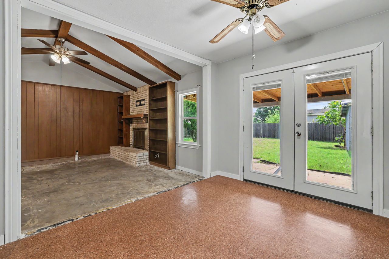 1811 Terry Lane Georgetown, TX 78628 - Photo 15 of 40 Vast living area with a charming brick fireplace, exposed beams, and patio access for indoor-outdoor living.