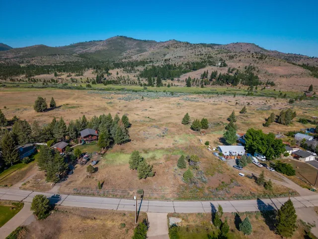 an aerial view of mountain with residential house and green space
