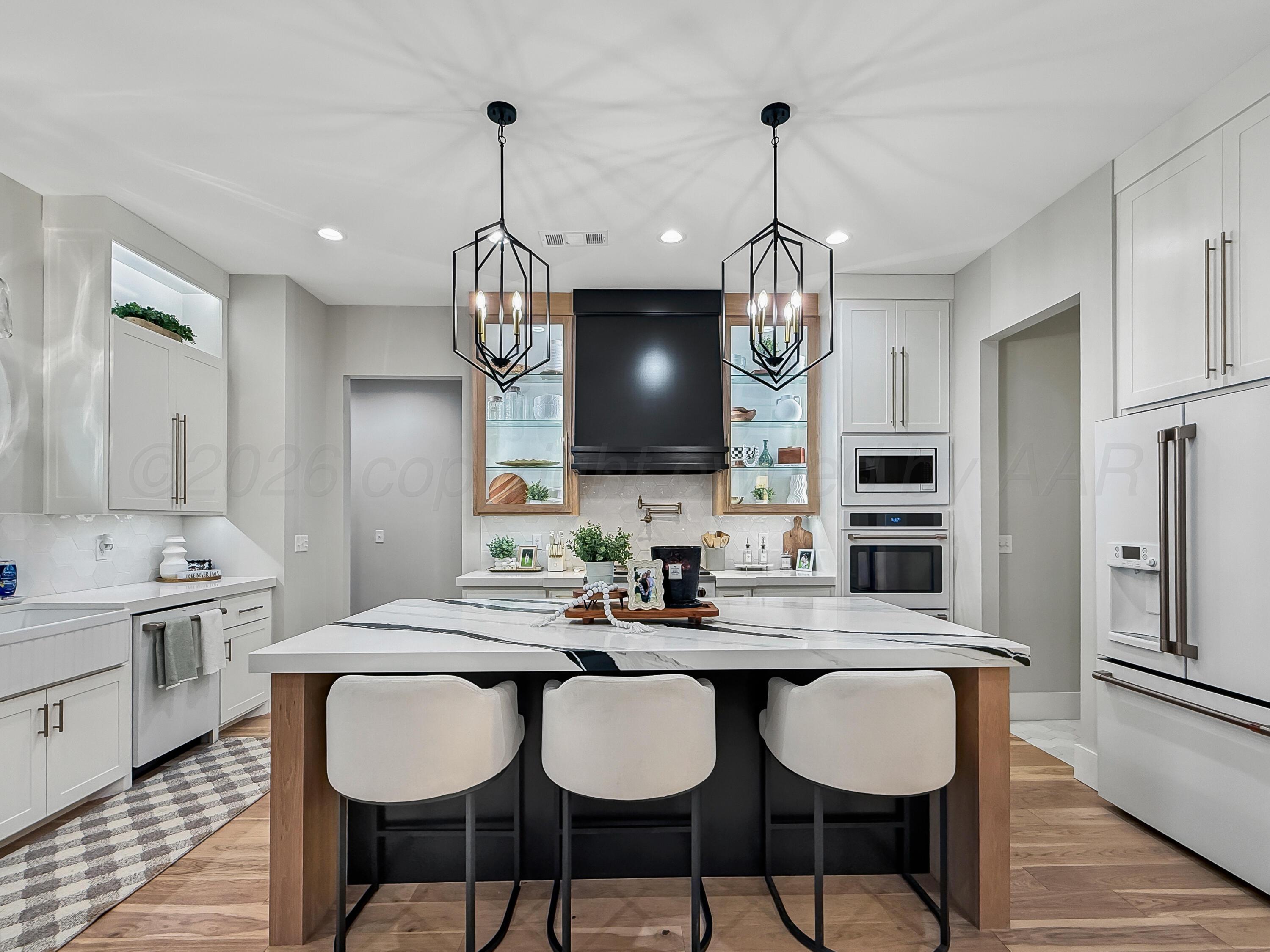 3701 Longhorn Springs Road Amarillo, TX 79119 - Photo 13 of 48 a dining room with wooden floor a chandelier a wooden table and chairs