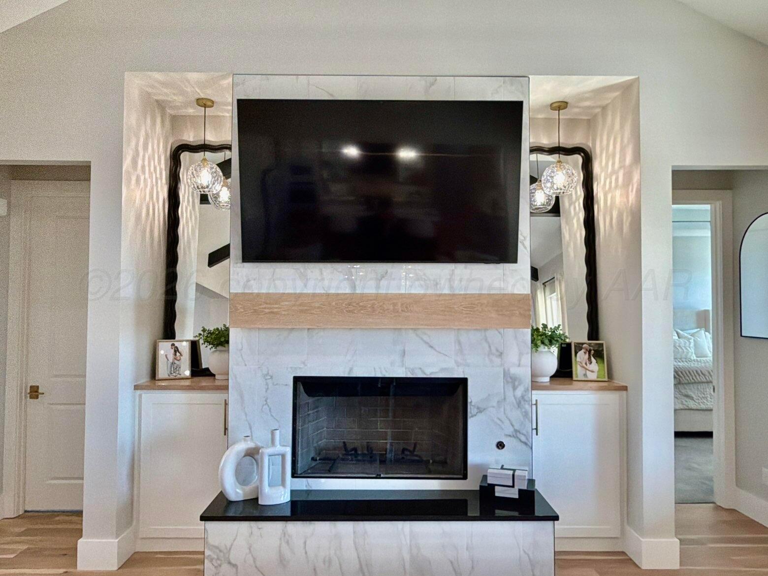 3701 Longhorn Springs Road Amarillo, TX 79119 - Photo 9 of 48 a living room with a fireplace and a flat screen tv