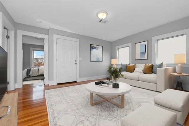 a living room with furniture a rug and a window