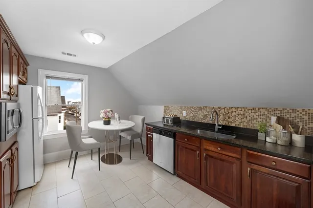 a kitchen with a sink and chairs