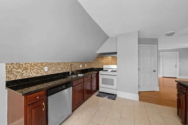 a kitchen with granite countertop a stove and a sink