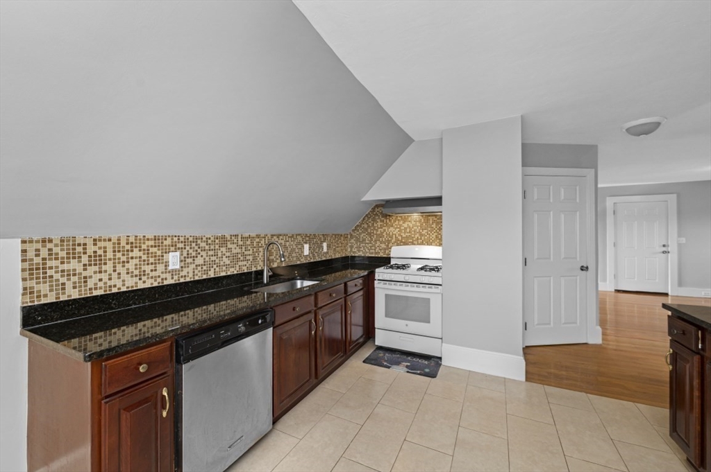 129 Lynnway, Unit 3 Revere, MA 02151 - Photo 5 of 14 a kitchen with granite countertop a stove and a sink