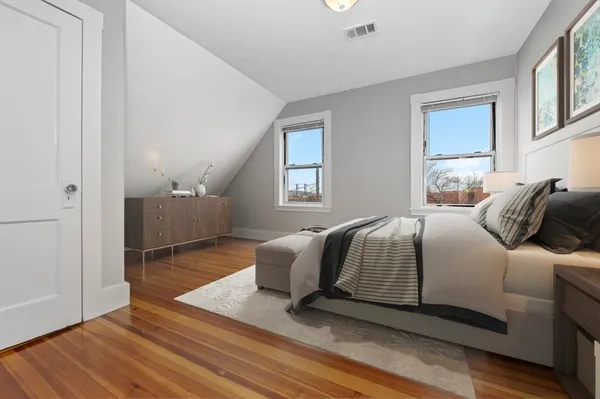 a bedroom with a bed and wooden floor