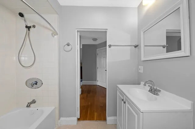 a bathroom with a tub sink and mirror
