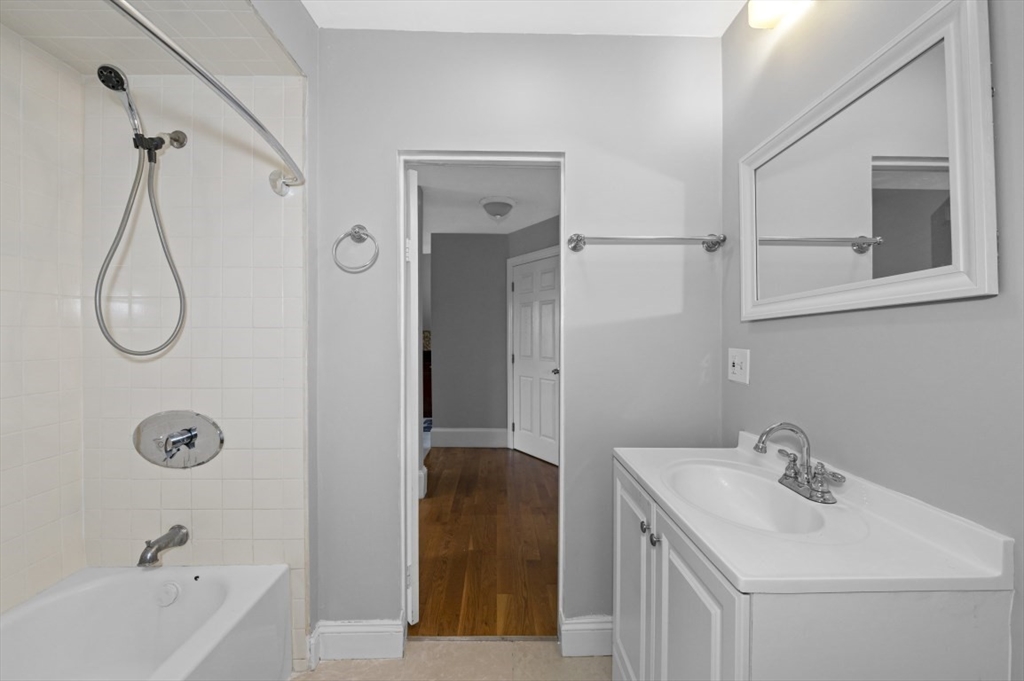 129 Lynnway, Unit 3 Revere, MA 02151 - Photo 7 of 14 a bathroom with a tub sink and mirror