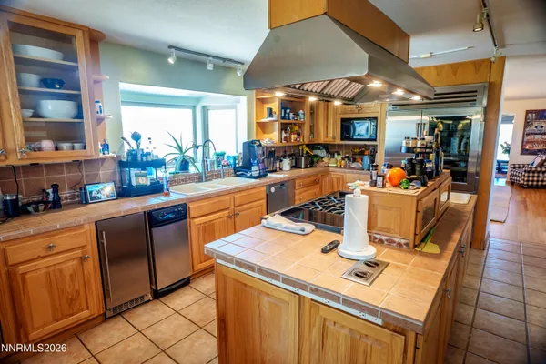 a view of a kitchen with a sink and dishwasher a refrigerator with white cabinets
