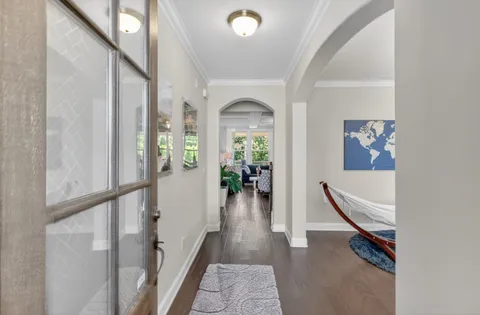 a view of a hallway with wooden floor and windows