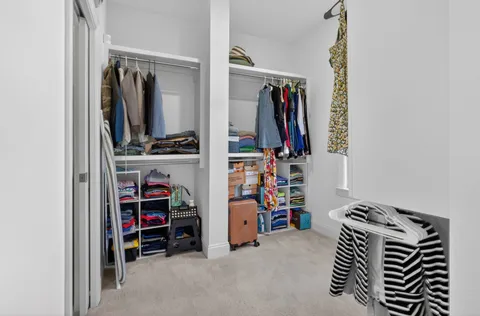 a view of walk in closet with clothes and shoes