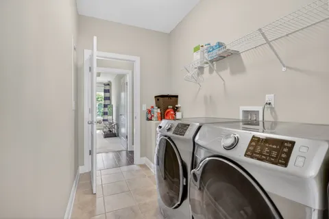 a utility room with dryer washer and a view of living room