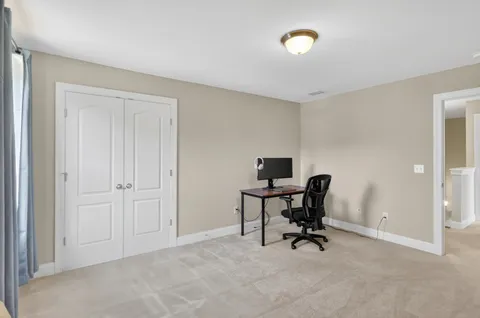 a view of a workspace with furniture and a window