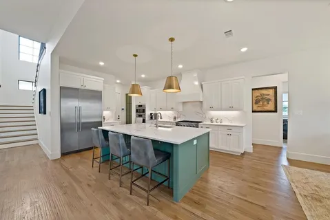 a kitchen with stainless steel appliances kitchen island hardwood floor sink stove and wooden cabinets