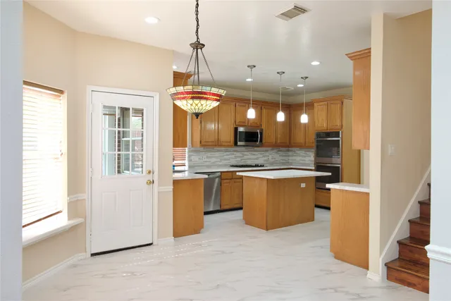 a view of a kitchen with a refrigerator a sink and cabinets