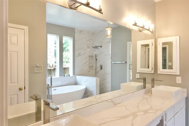 a bathroom with a granite countertop tub sink and shower