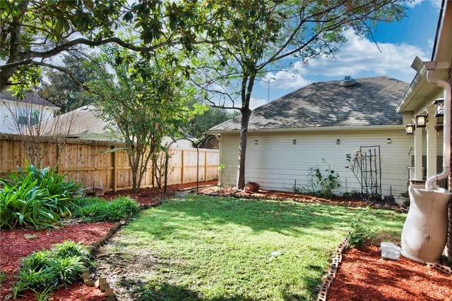a backyard of a house with lots of green space and fountain